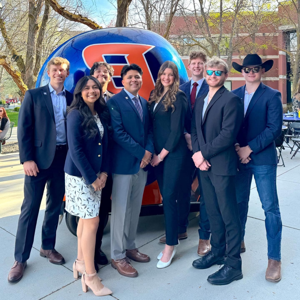 Nick Lloyd standing among fellow ASBSU students in front of a helmet car.